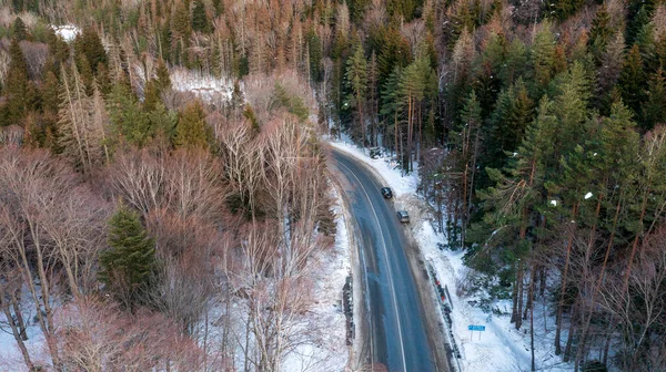 Dağlarda kış yolu, havadan, üstten manzara, kışın kıvrımlı bir yolun havadan görünüşü.