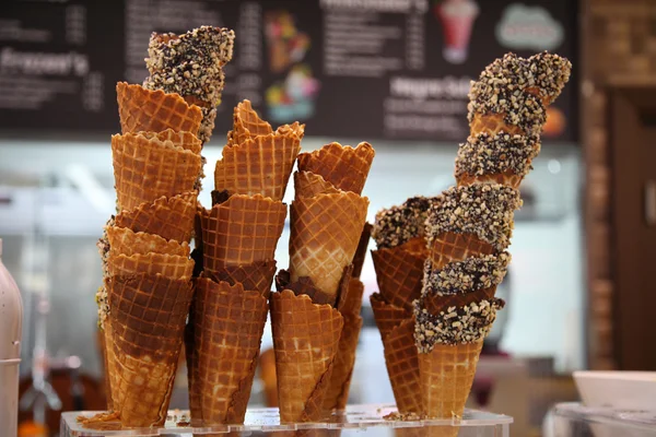 Вафельные рожки с шоколадом и орехами для мороженого на прилавке Стоковое Изображение