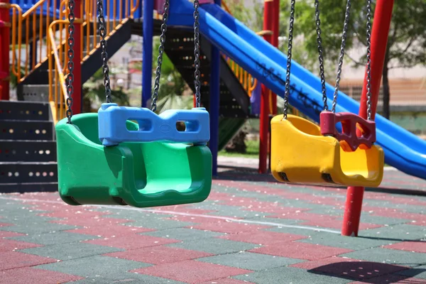 Разноцветные детские качели на детской площадке на открытом воздухе Лицензионные Стоковые Фото