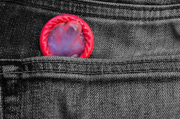 Red condom pack in back pocket jeans,abortion concept. — Stock Photo, Image