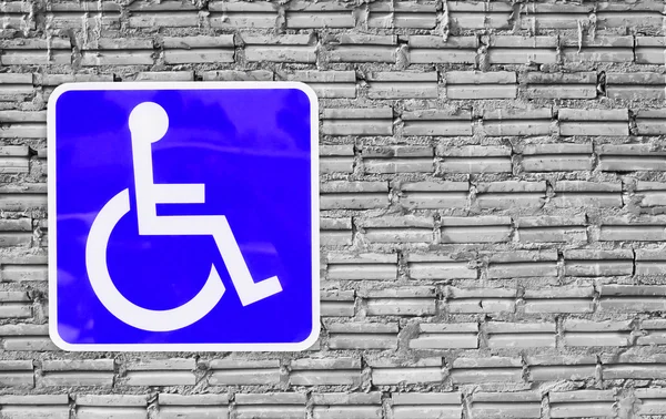 Handicap badge op muur bakstenen. — Stockfoto