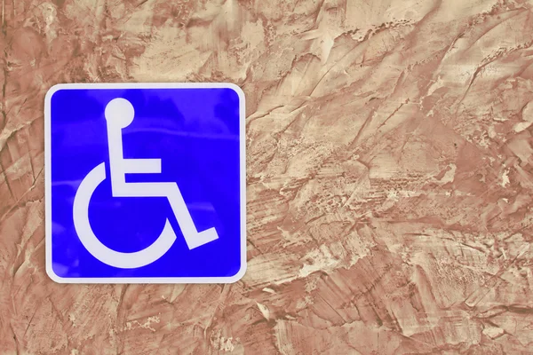 Blue handicap estacionamiento o silla de ruedas en la pared Cemento texturizado fondo — Foto de Stock