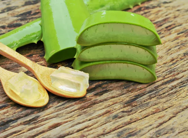 Aloe vera gel on wooden spoon with wooden table Royalty Free Stock Images