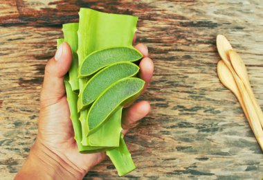 Aloe vera jel ahşap masa tahta kaşıkla üzerinde tutan el