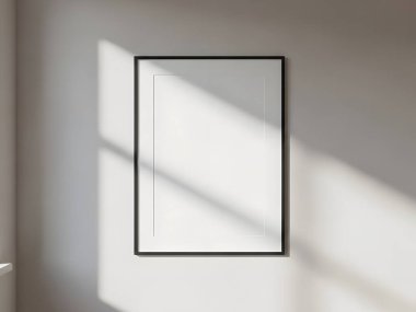 Parlak siyah bir çerçeve, güneş ışığı ve gölgelerle yıkanmış beyaz bir duvara asılarak modern minimalist bir ortam yaratıyor..