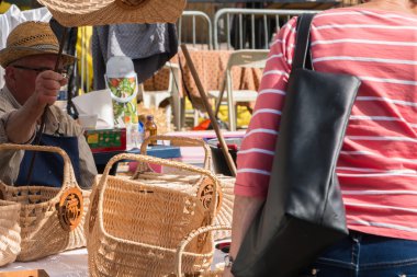 adam bir pazarda hasır sepetler satıyor