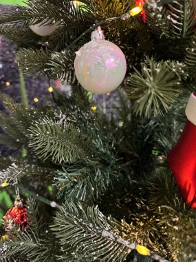 Yılbaşı ağacı dallarının beyaz bir oyuncağı ve güzel süslemeleri ile arka planında