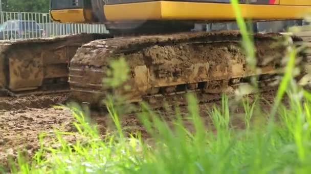 Excavadora amarilla en un sitio de construcción diciendo — Vídeos de Stock