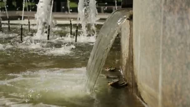 Stikaet de agua abajo. Una pequeña cascada en una fuente . — Vídeo de stock