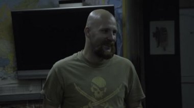 Bir kafatası ile bir T-shirt kel adam diyor. Bir korsan göğüs ile sakallı adam der ki