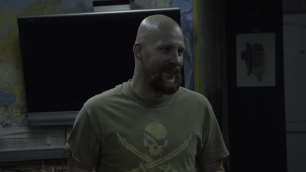 Łysy mężczyzna w T-shirt z czaszki mówi. Brodaty facet z piratem na klatce piersiowej mówi — Wideo stockowe