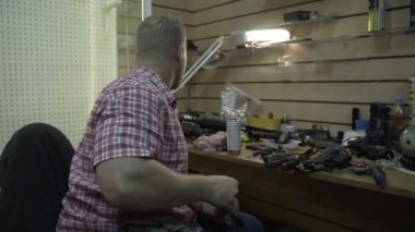 Adam silah tamiri. Sakallı adam temizler ve stüdyoda onun masasında armekie tüfek ve tabanca onarır