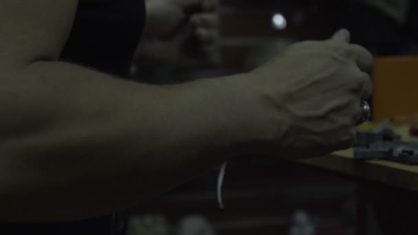 Muž, opravy zbraní. Chlap s plnovousem čistí a opravuje armekie pušky a pistole na stole v dílně — Stock video