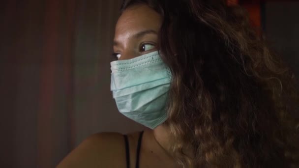 Κυρία με μάσκα μιας χρήσης για την πρόληψη της ασθένειας στο σκοτεινό δωμάτιο — Αρχείο Βίντεο