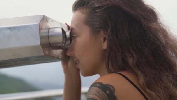 Signora con i capelli lunghi e sguardo tatuaggio in cannocchiale binoculare — Video Stock