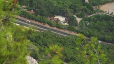 Otomobiller yaz günü küçük bir kasabadan geçerken yol boyunca sürüyorlar.