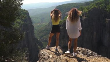 Kadınlar uzak dağların kıyısında durmaktan hoşlanırlar.