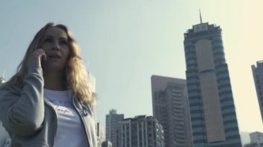 Çin caddesinde kadın cep telefonuyla konuşuyor.