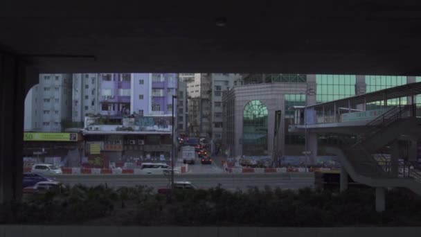 Automóviles y autobuses a lo largo de la calle más allá de los edificios altos — Vídeo de stock