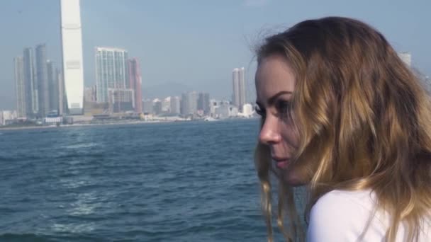 Femme regarde l'eau de mer azur contre les bâtiments élevés — Video