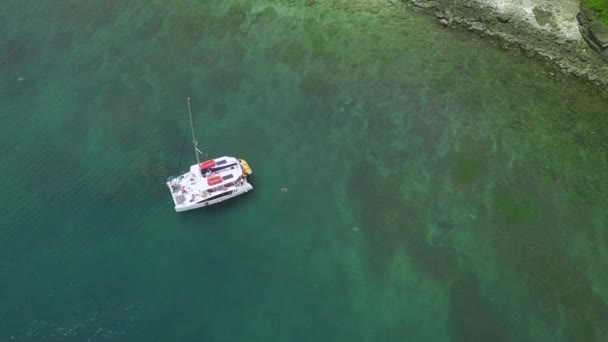Белый корабль со спущенными парусами дрейфует по воде прозрачного океана — стоковое видео