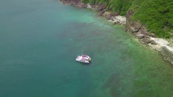 L'uomo nuota vicino yacht alla deriva sul tranquillo azzurro mare da costa — Video Stock