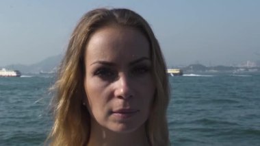 Dağın ve şehrin yanından geçen gemilerle okyanusta bir kadın.