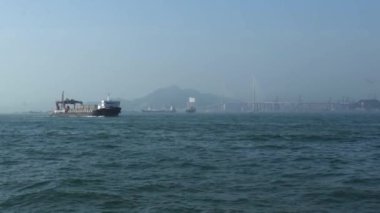 Gök mavisi okyanus suyu boyunca konteynırları olan kargo gemisi.