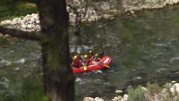 戴着头盔和背心的游客沿着山河划船 — 图库视频影像