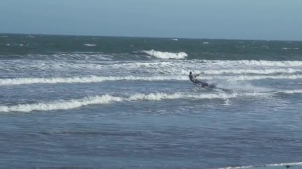 Sportieve atleten rijden op eindeloze blauwe oceaan ondiepe golven — Stockvideo