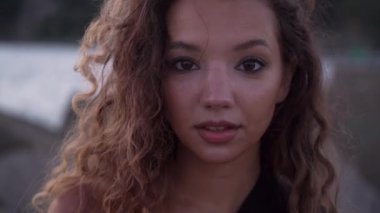 Uzun kıvırcık saçlı profesyonel model gölde poz veriyor.