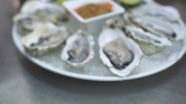 Şef bir dilim limonu istiridye ve sosla tabağa koyar.