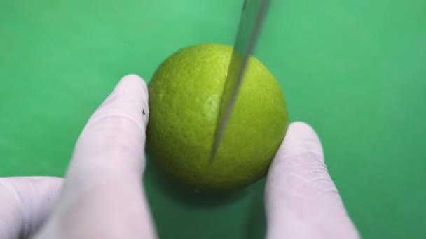 Шеф розрізає смачне кисле лаймо на зеленій дошці на кухні крупним планом — стокове відео