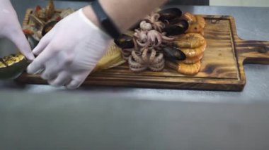 Adam güverteye portakallı ızgara koyuyor.