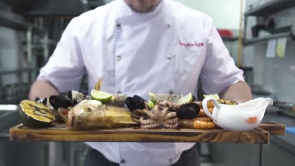 Man puts set of delicious grilled sea delicacies on shelf — Stock Video