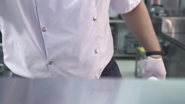 Az egyenruhás alkalmazott fémpolcot tisztít az éttermi konyhában. — Stock videók