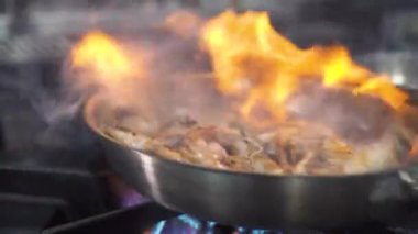 Restoranın mutfağında tavada kraliyet karideslerini kızartmak.