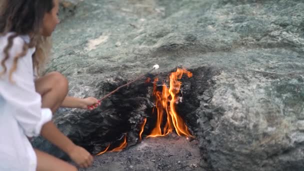 Señora sostiene palo de malvavisco sobre fuego de montaña Chimaera — Vídeos de Stock