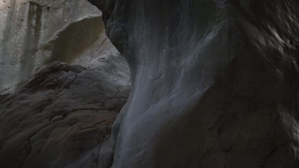 Große Höhle mit Felsen von seltsamer Form und Loch zum Sonnenlicht — Stockvideo