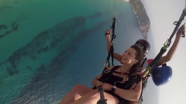 Junge Frau lächelt beim Fliegen mit bärtigem Mann am Fallschirm — Stockvideo