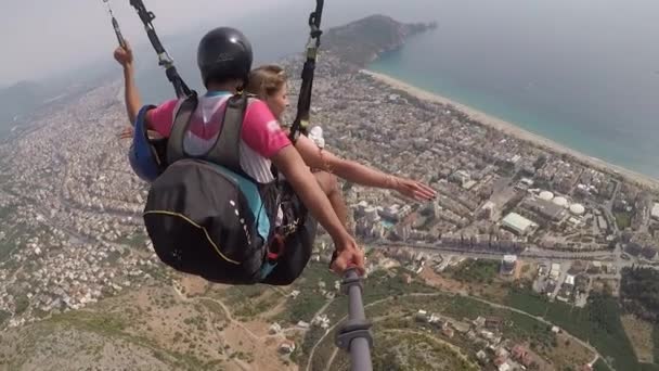 Professionele skydiver parachutes toerist over kleine stad — Stockvideo