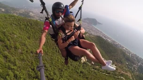 Des parachutistes amusés survolent des forêts verdoyantes en parachute — Video