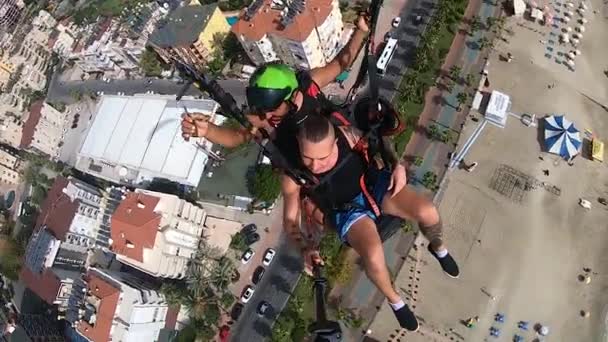 Paracaidistas extremos vuelan en paracaídas sobre paisaje urbano en verano — Vídeos de Stock