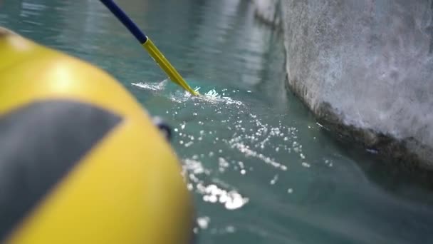 Bateau en caoutchouc noir et jaune navigue le long de la surface de l'eau bleue — Video