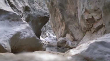 Kayalıklardan yansıyan parlak güneş ışığıyla küçük sakin göl