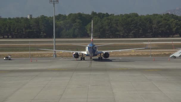 Avión gris se levanta sobre delantal de hormigón reflejando la luz del sol — Vídeos de Stock