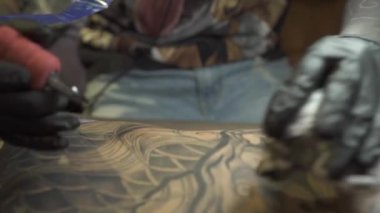 Deneyimli dövme salonu çalışanı, kişinin sırtından mürekkep siler.