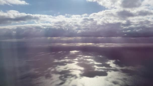 Fényes napsugarak törik át a fehér vastag felhőket az óceánon — Stock videók