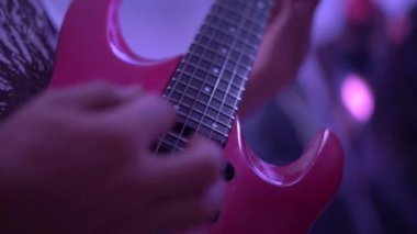 Rock müzisyeni sahnede kırmızı elektro gitar çalıyor