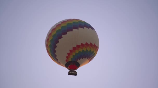 Varm luft ballong med regnbåge och vita ränder flyter på himlen — Stockvideo